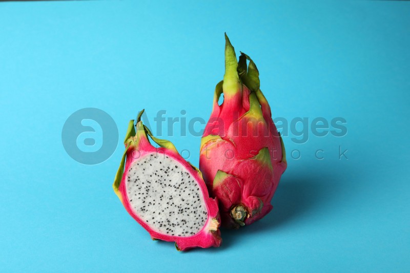 Delicious cut and whole white pitahaya fruits on light blue background