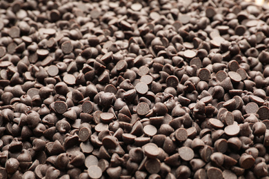 Delicious chocolate chips as background, closeup view