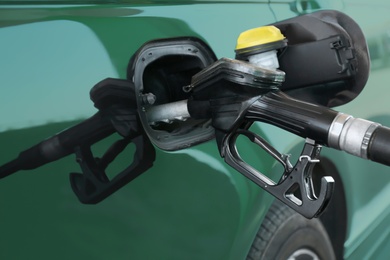 Refilling car with fuel at gas station, closeup