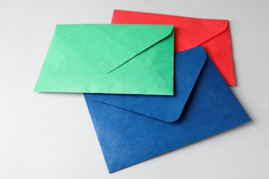Colorful paper envelopes on light grey background. Mail service