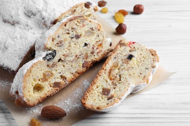 Traditional Christmas Stollen with icing sugar on white wooden table, closeup