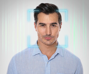 Facial recognition system. Young man with scanner frame and digital biometric grid on light background