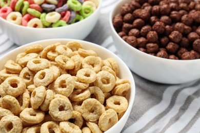 Different delicious breakfast cereals on kitchen towel, closeup
