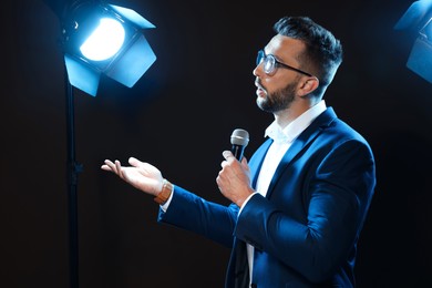 Motivational speaker with microphone performing on stage