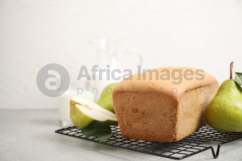 Photo of Tasty bread and pears on light grey table. Homemade cake