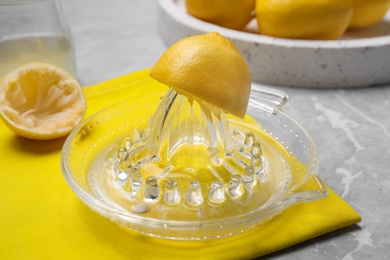 Glass citrus juicer and squeezed lemon on table