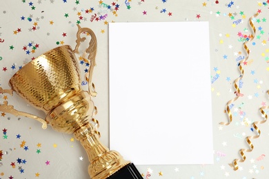 Trophy and blank paper on light background, top view with space for text. Victory concept
