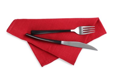Red napkin with fork and knife on white background, top view