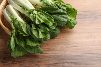 Fresh green pak choy cabbages on wooden table, space for text