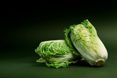 Fresh ripe Chinese cabbages on green background, space for text