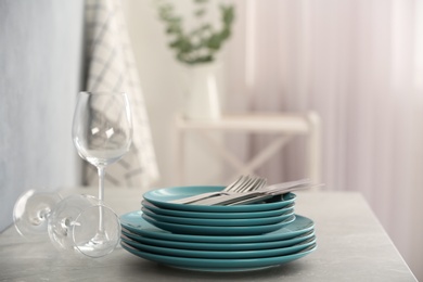 Set of clean dishware, cutlery and wineglasses on grey table indoors. Space for text