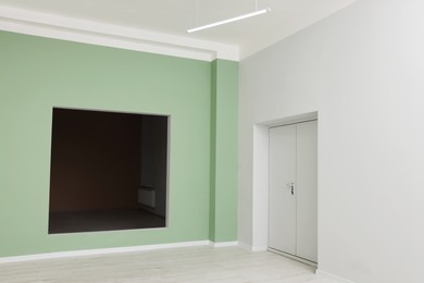 Photo of Empty office room with color walls. Opening for fake window