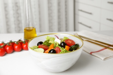 Tasty fresh Greek salad on white table