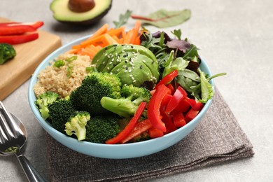 Photo of Delicious vegan bowl with bell peppers, avocados and broccoli on table, closeup