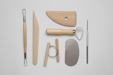 Set of clay modeling tools on white background, flat lay