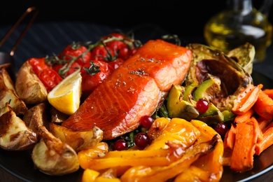 Photo of Tasty cooked salmon and vegetables on plate, closeup. Healthy meals from air fryer