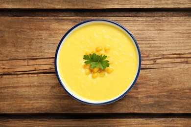 Delicious creamy corn soup on wooden table, top view