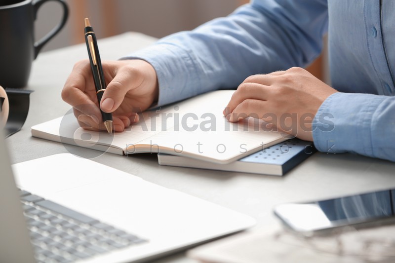 Journalist working at table in office, closeup