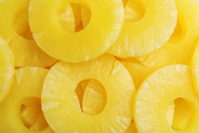 Pieces of delicious sweet canned pineapple as background, closeup