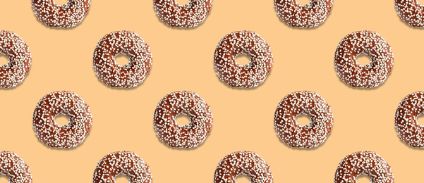 Image of Creative pattern design of glazed donuts on pale orange background, banner
