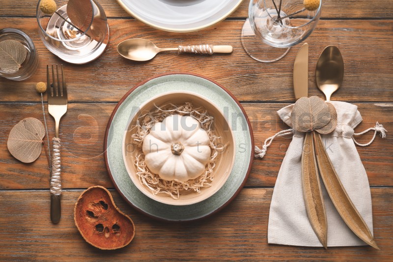 Autumn table setting with pumpkin and decor on wooden background, flat lay