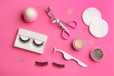 Flat lay composition with magnetic eyelashes and accessories on crimson background