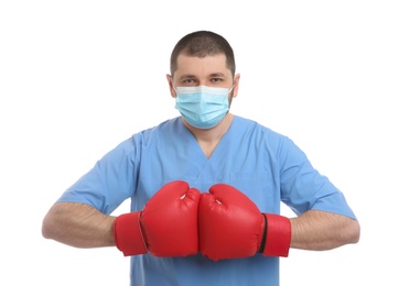 Doctor with protective mask and boxing gloves on white background. Strong immunity concept
