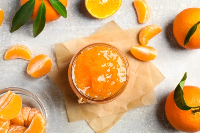 Flat lay composition with delicious tangerine jam on light grey table