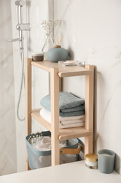 Photo of Shelving unit with clean towels in bathroom interior