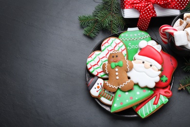 Photo of Delicious gingerbread Christmas cookies on black table, flat lay. Space for text