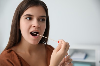 Woman taking sample for DNA test indoors