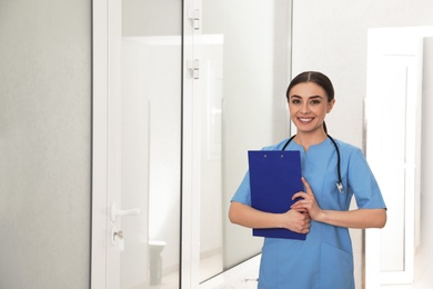 Portrait of nurse with clipboard in hospital hallway. Medical assisting