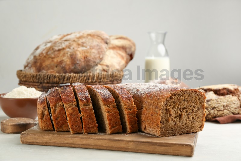 Cut freshly baked bread on white wooden table