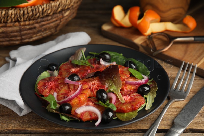 Photo of Plate of delicious sicilian orange salad on wooden table