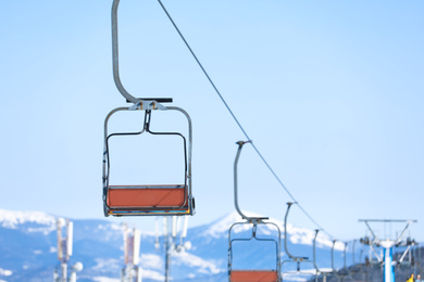 Photo of Empty chairlift at mountain ski resort, space for text. Winter vacation