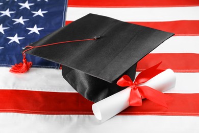Graduation hat and diploma on flag of United States