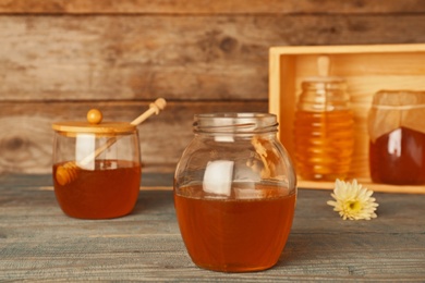 Glassware with tasty honey on wooden table