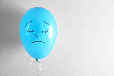 Air balloon with drawn sad face on white background. Space for text