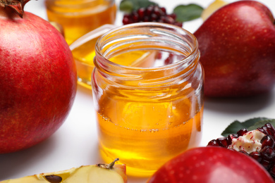 Honey, apples and pomegranate on white background, closeup. Rosh Hashanah holiday