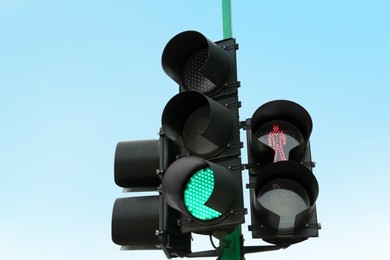 Traffic lights with red and green signals against blue sky