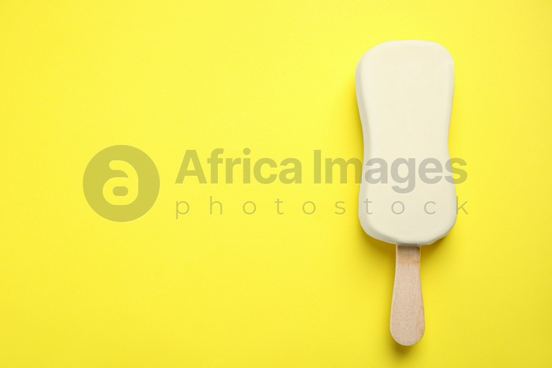 Photo of Ice cream with glaze on yellow background, top view. Space for text