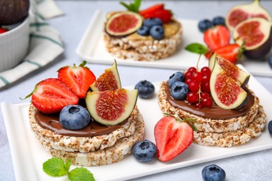 Tasty crispbreads with chocolate, figs and berries served on light table