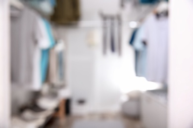 Blurred view of modern dressing room with stylish clothes