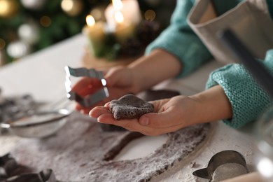 Little child making Christmas cookies at white table, closeup
