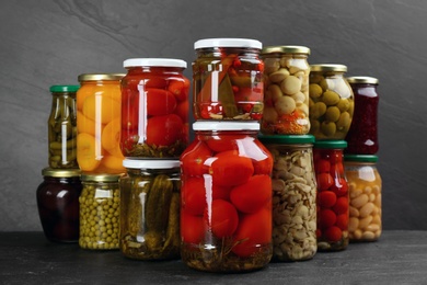 Jars of pickled vegetables on grey table