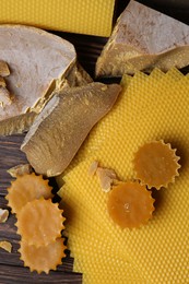 Photo of Different natural beeswax blocks and sheets on wooden table, flat lay