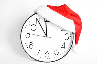 Clock with Santa hat showing five minutes until midnight on white background. New Year countdown