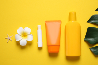 Flat lay composition with sun protection products on yellow background