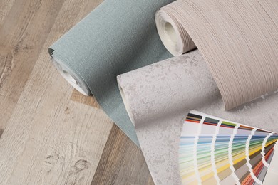 Wall paper rolls and color palette on wooden floor