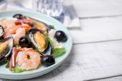 Photo of Plate of delicious salad with seafood on white wooden table, closeup. Space for text